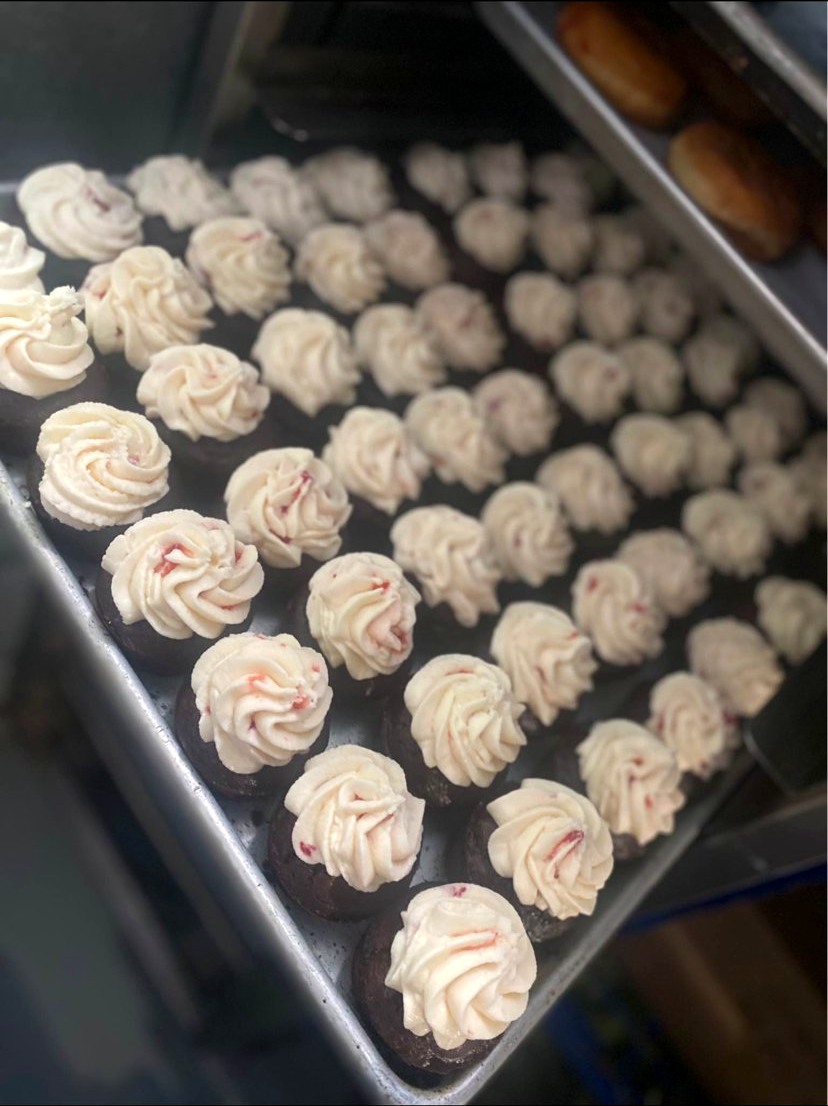 Small frosted bakes arranged on a tray