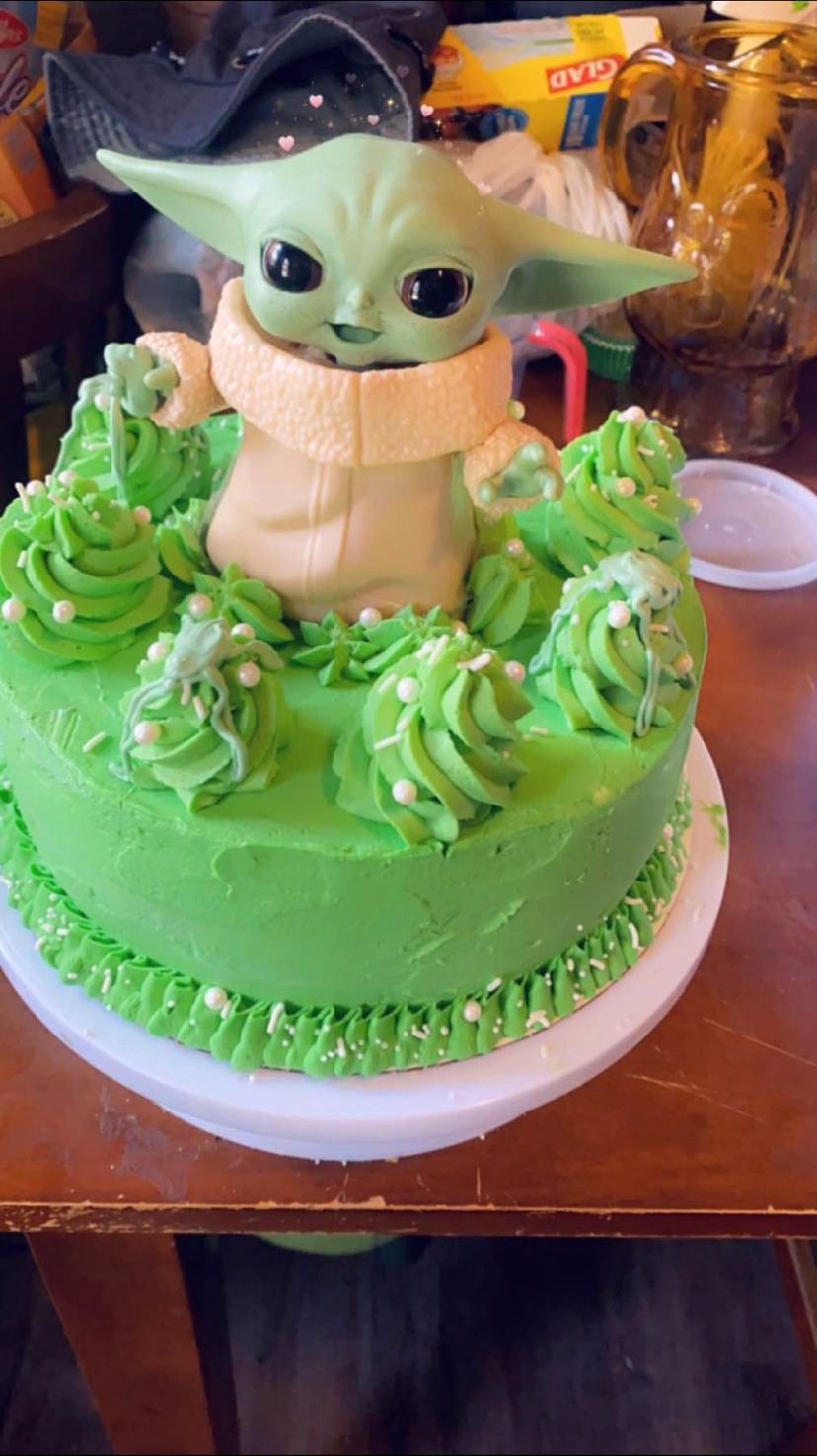 Green frosted cake with a character topper